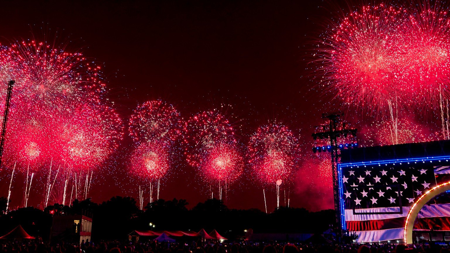 Red and gold fireworks filling the sky above the Salute to America stage.